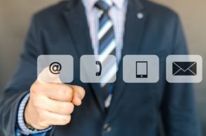 Image of a business man with email, phone, tablet, and mail icons in the foreground. Contact Core Alliance Management for your property management needs.